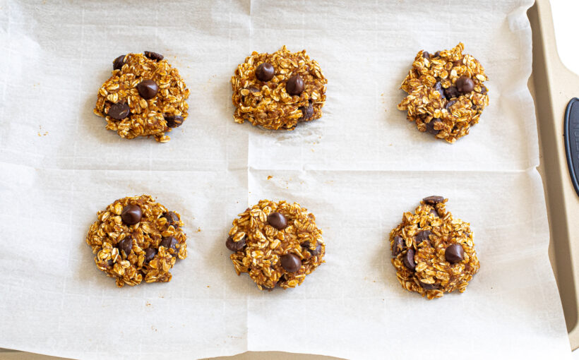 Pumpkin cookies on a baking sheet after being baked.