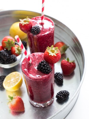 Top shot of berry slush drink in glass cups next to fresh berries.
