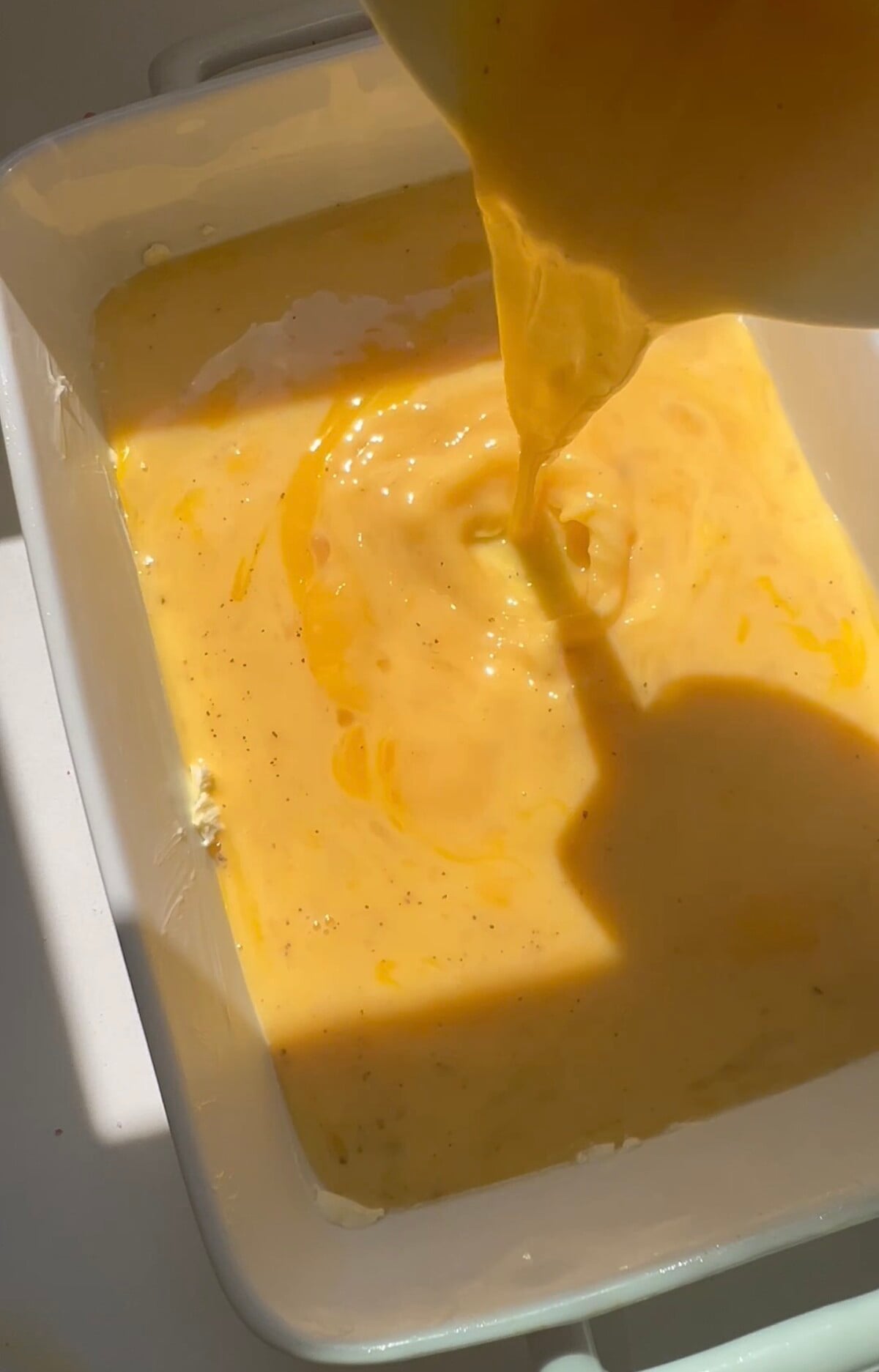 pouring eggs in 9 x 13 casserole dish