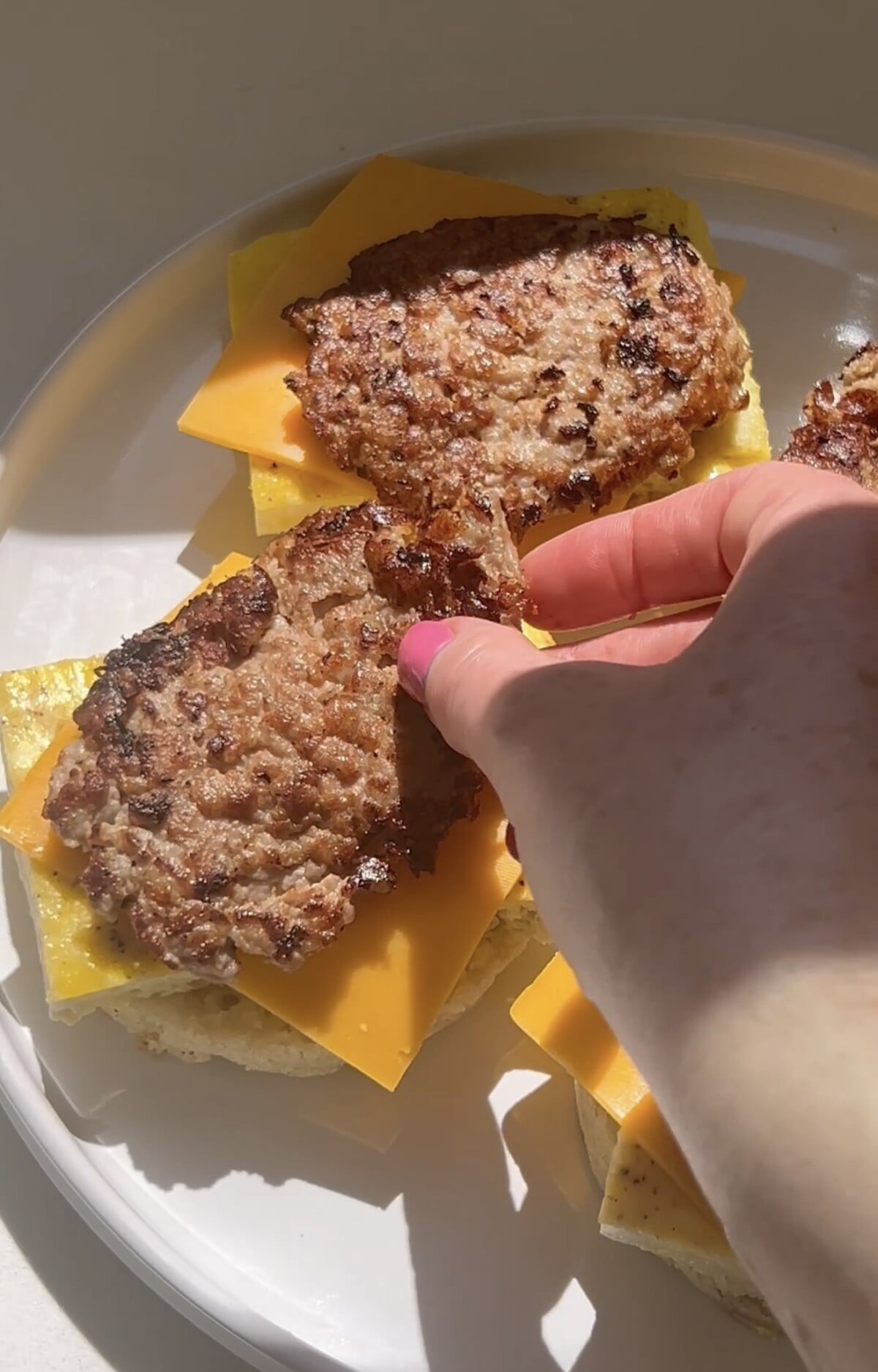 topping homemade McMuffins with homemade chicken breakfast sausage