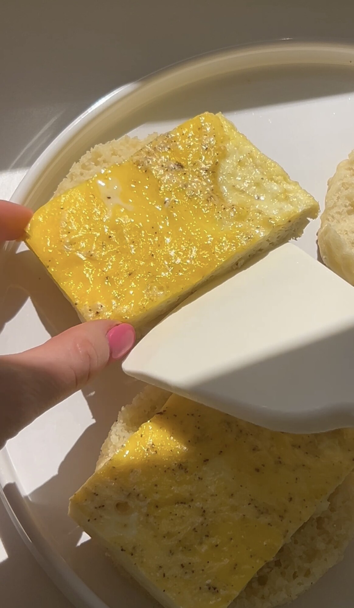 author placing rectangle of egg onto homemade English muffin