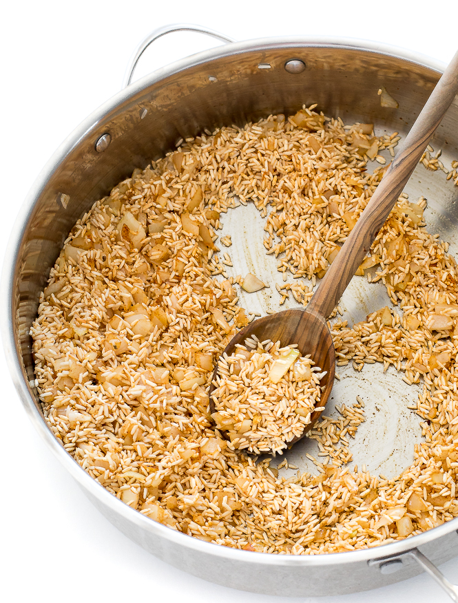 Toasting rice and onions and garlic in oil in saute pan