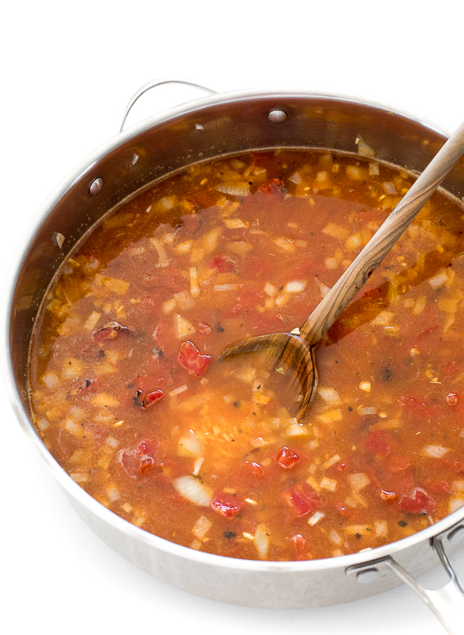 Adding in tomatoes and chicken broth to pan