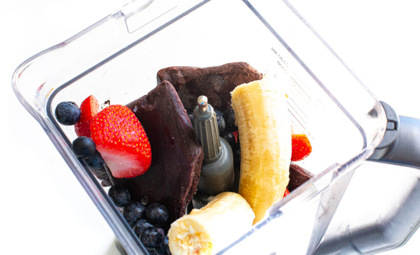 Ingredients for acai bowls in a smoothie before being blended. 
