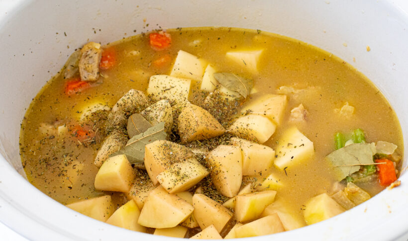 The chicken stew mixture in a white slow cooker.