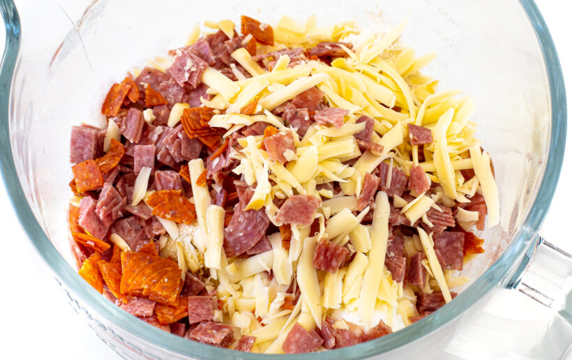 adding salami, pepperoni and shredded cheese to whipped egg whites