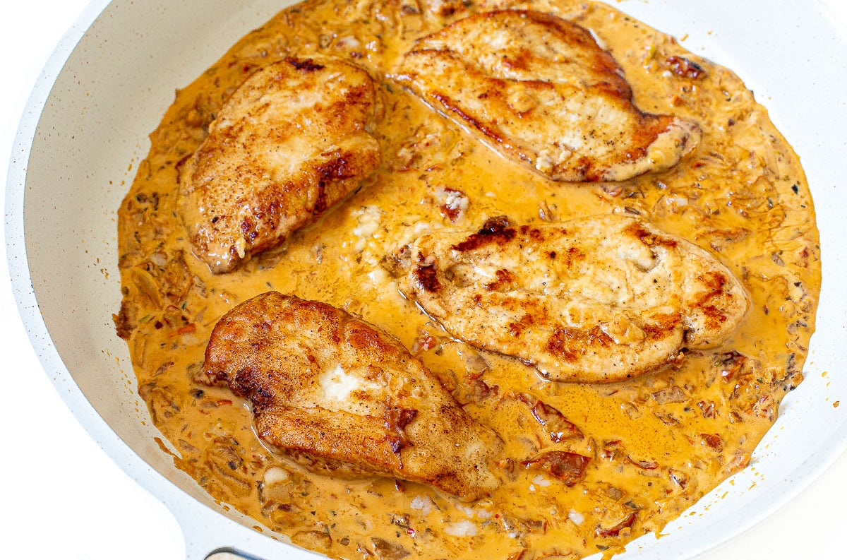 adding chicken breasts back to the marry me chicken sauce in pan