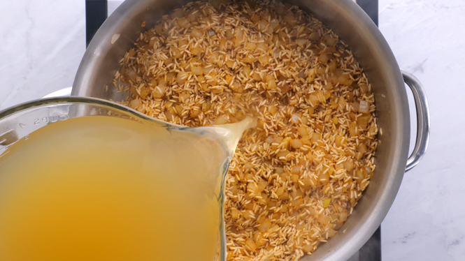 adding chicken stock to rice