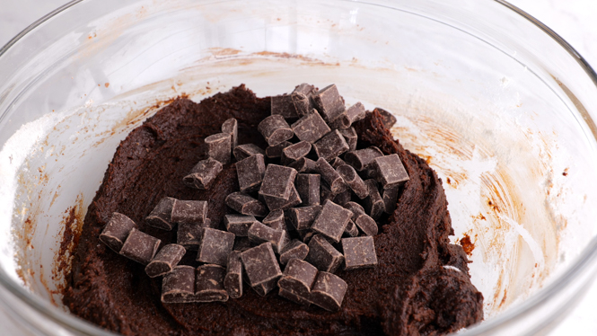 Brownie batter and chocolate chunks in a mixing bowl.