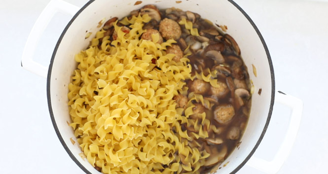 adding uncooked egg noodles to pot