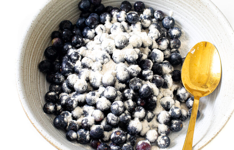 Blueberries tossed with flour in a bowl.