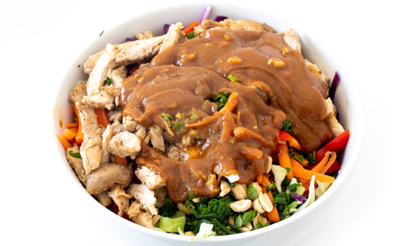 Salad with the peanut dressing poured on top before being mixed. 