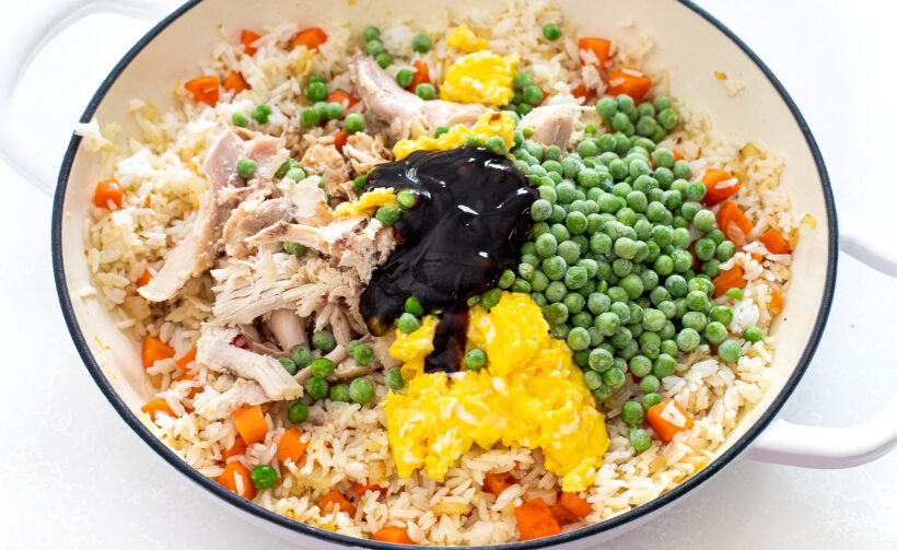 Chicken fried rice ingredients in a white sauté pan. 