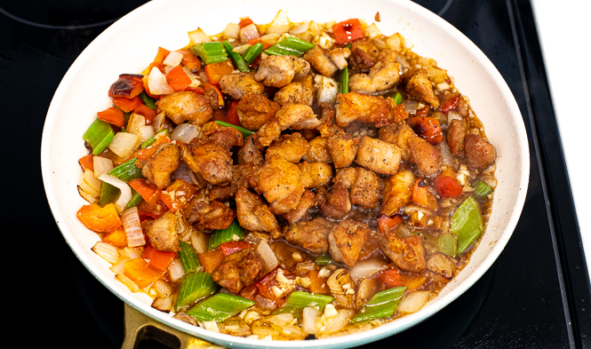 Black pepper chicken in a wok on the stove.