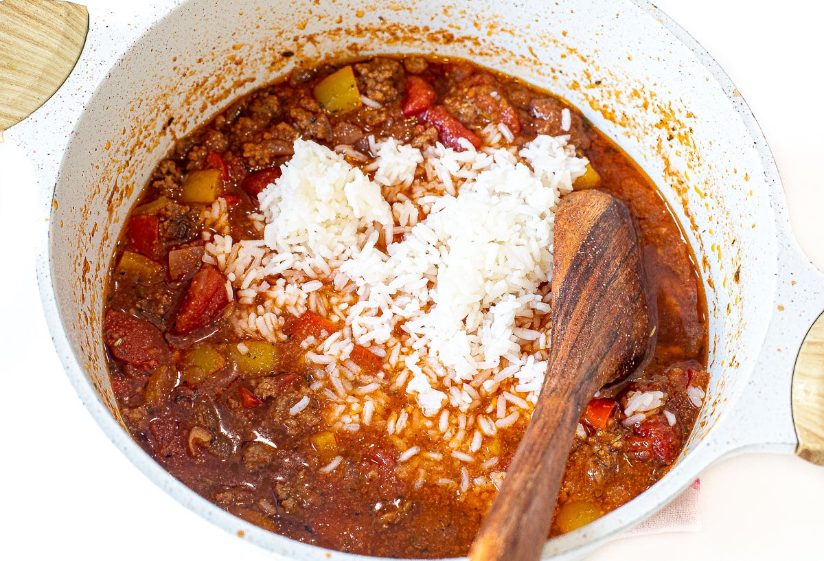 Stirring rice into stuffed pepper soup.