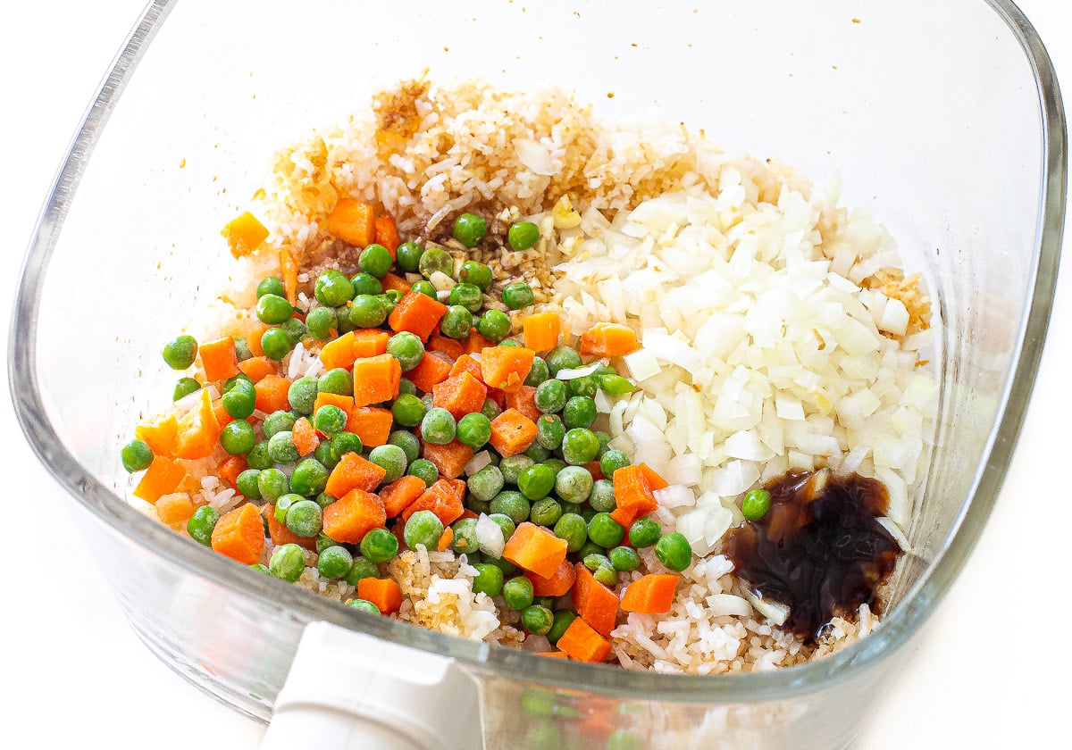 adding frozen veggies, sauce, garlic and onion to air fryer fried rice