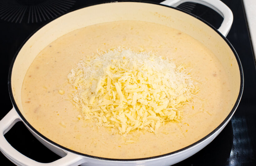 Cheese in a sauté pan with a milk sauce.