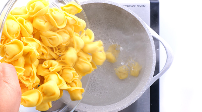 adding tortellinis to boiling water