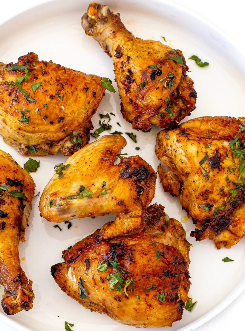 Crispy pieces of chicken served on a plate and garnished with herbs. 