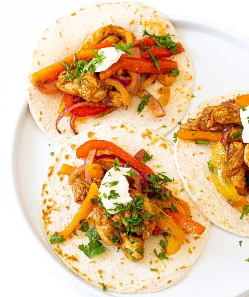 Warm flour tortillas topped with chicken fajita filling, dollop of sour cream and cilantro.