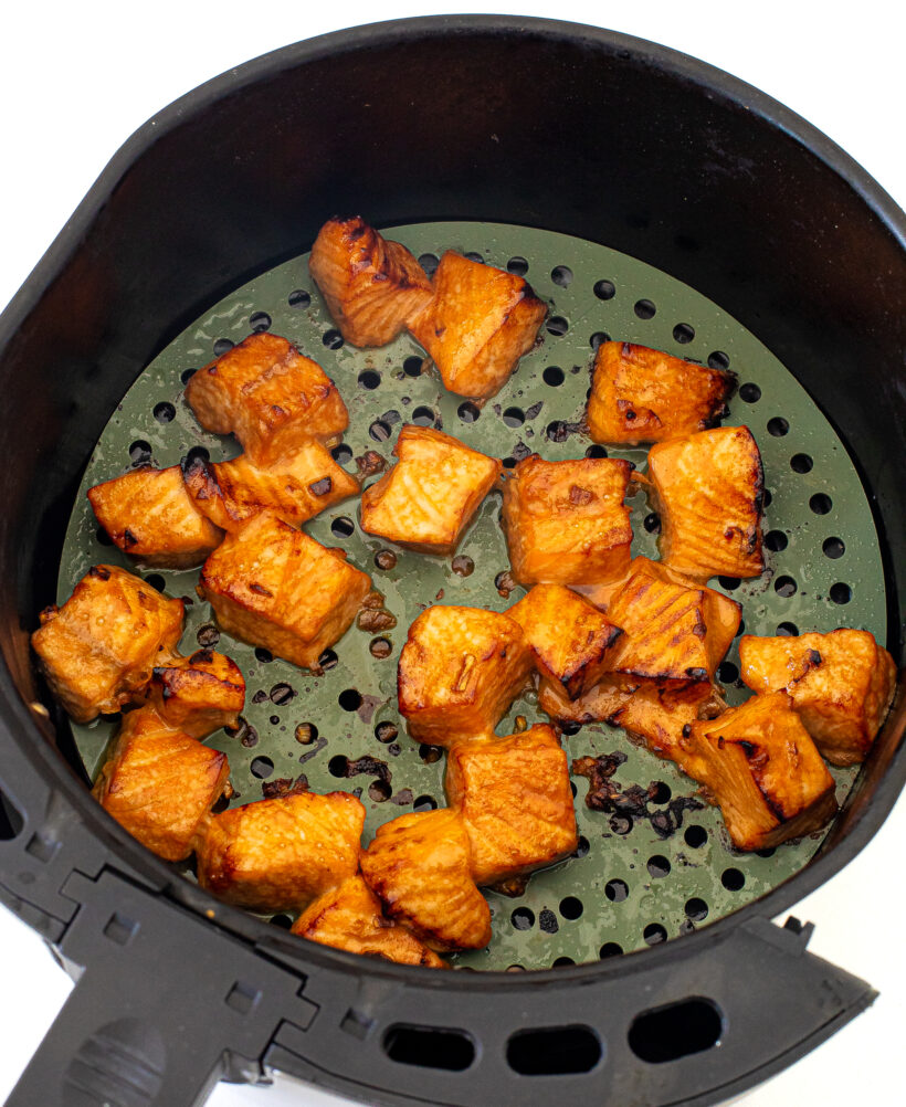 Salmon bites being cooked in an air fryer. 