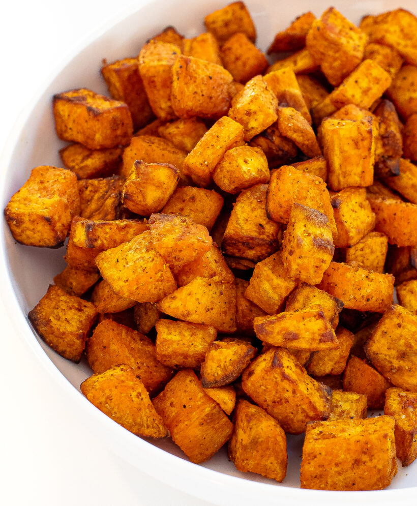 Dices and roasted sweet potatoes in a white serving bowl.