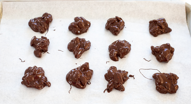 portioning almond clusters on baking sheet lined with parchment paper