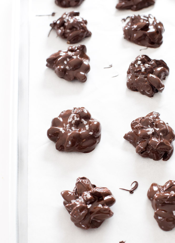 dark chocolate almond clusters placed on parchment paper