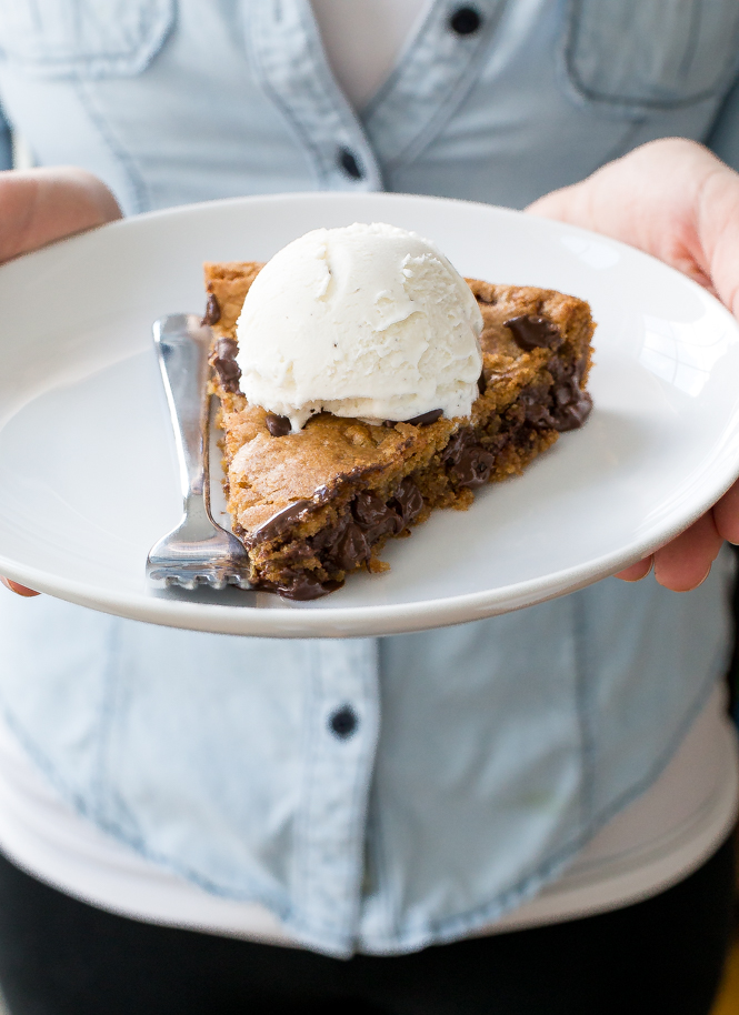 the chef holding a white plate with a slice of this Brown Butter Chocolate Chip Skillet Cookie topped with a scoop of vanilla ice cream | chefsavvy.com