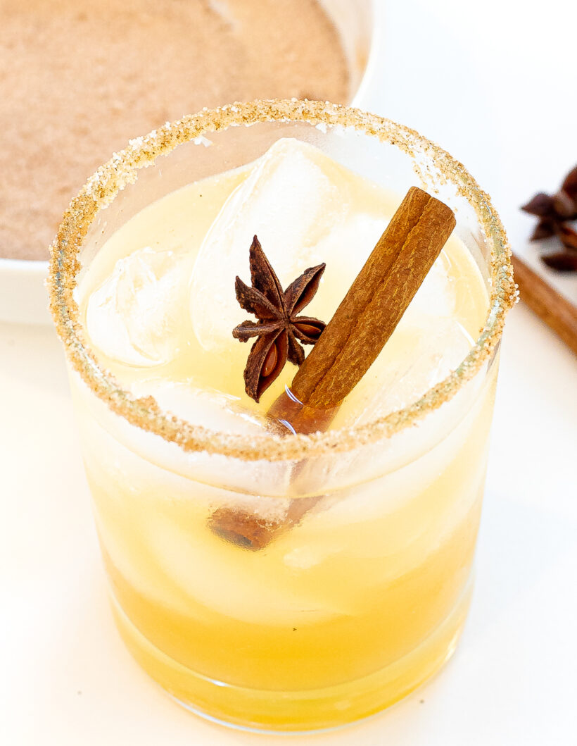 Homemade apple cider margarita in a rocks glass topped with cinnamon and star anise.