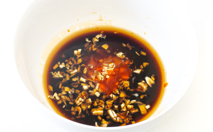 Soy sauce, sesame oil, garlic and sriracha in a mixing bowl. 