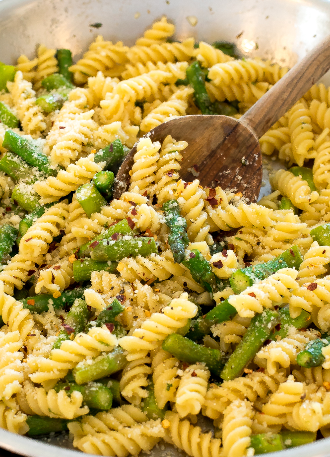 close up of this Lemon Asparagus Pasta in a large skillet with a wooden spoon
