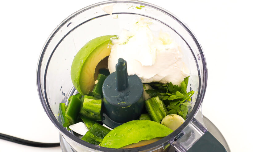 Ingredients for avocado cream recipe in a food processor. 