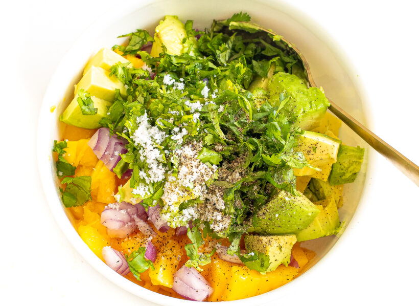 Ingredients for mango salsa in a bowl before being combined.