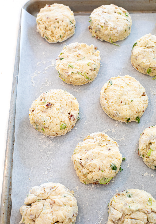 unbaked biscuits on baking sheet lines with parchment paper