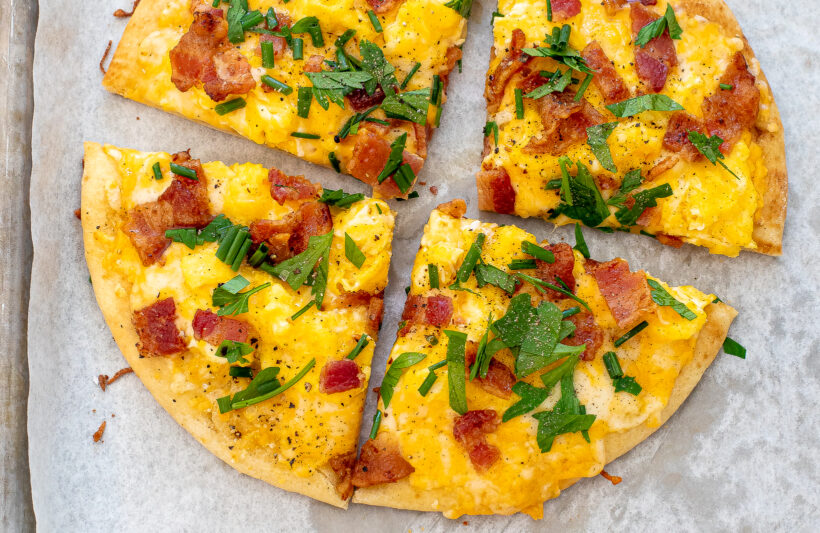 Overhead view of pita pizza on a baking sheet. 