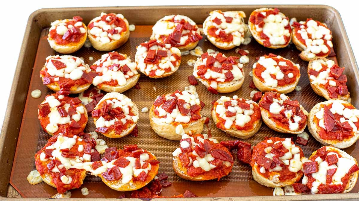 baked mini pizza bagels on baking sheet