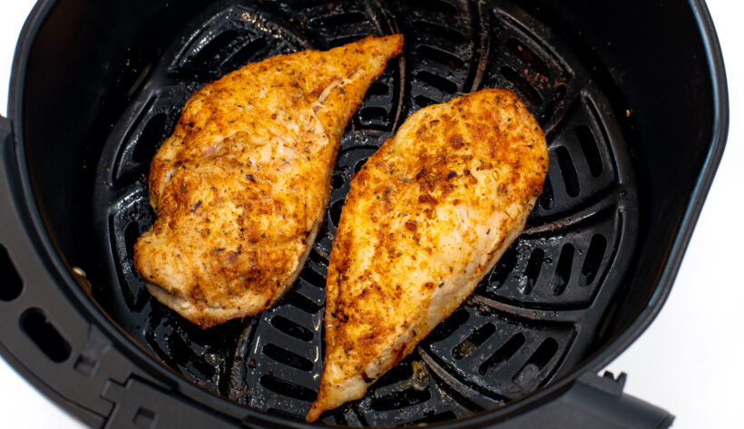 Chicken breast in the air fryer basket after being cooked.