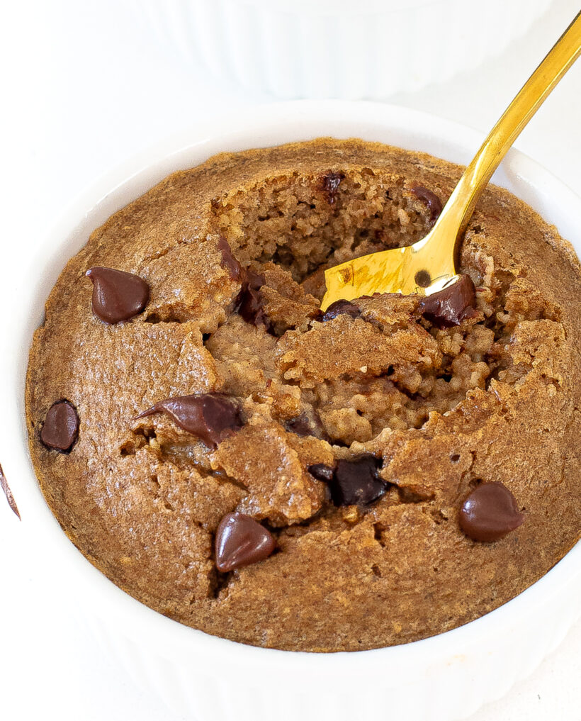 Close up shot of baked oats with a golden spoon taking a bite. 