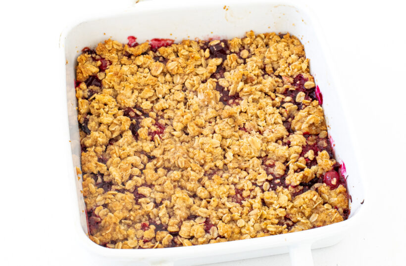 Baked cranberry crumb bars in a white baking dish.