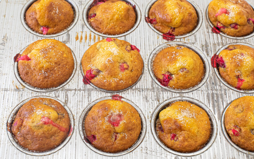 Baked cranberry orange muffins in a muffin tin.