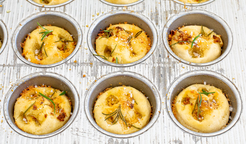Rosemary focaccia muffins in the muffin tin after being baked. 