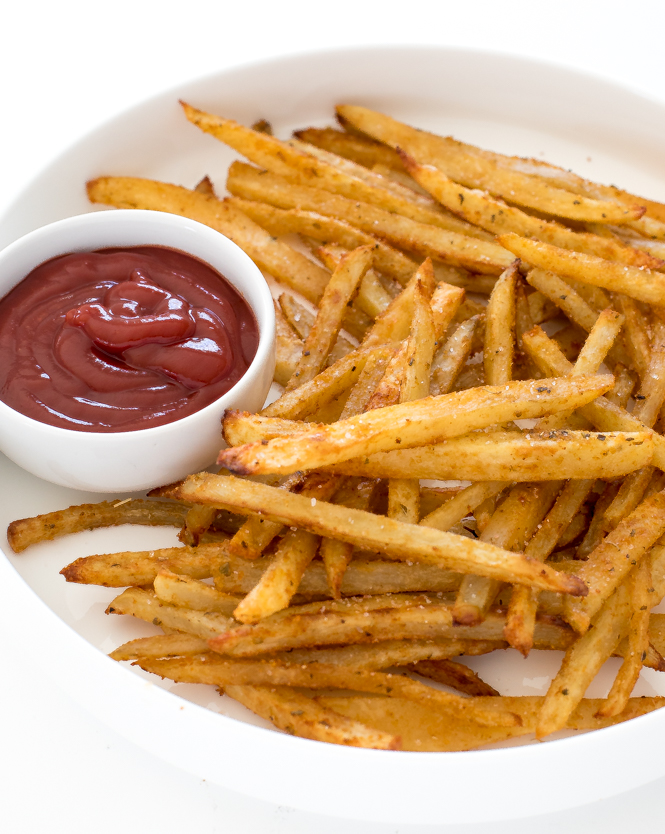 Fries on a white plate with ketchup