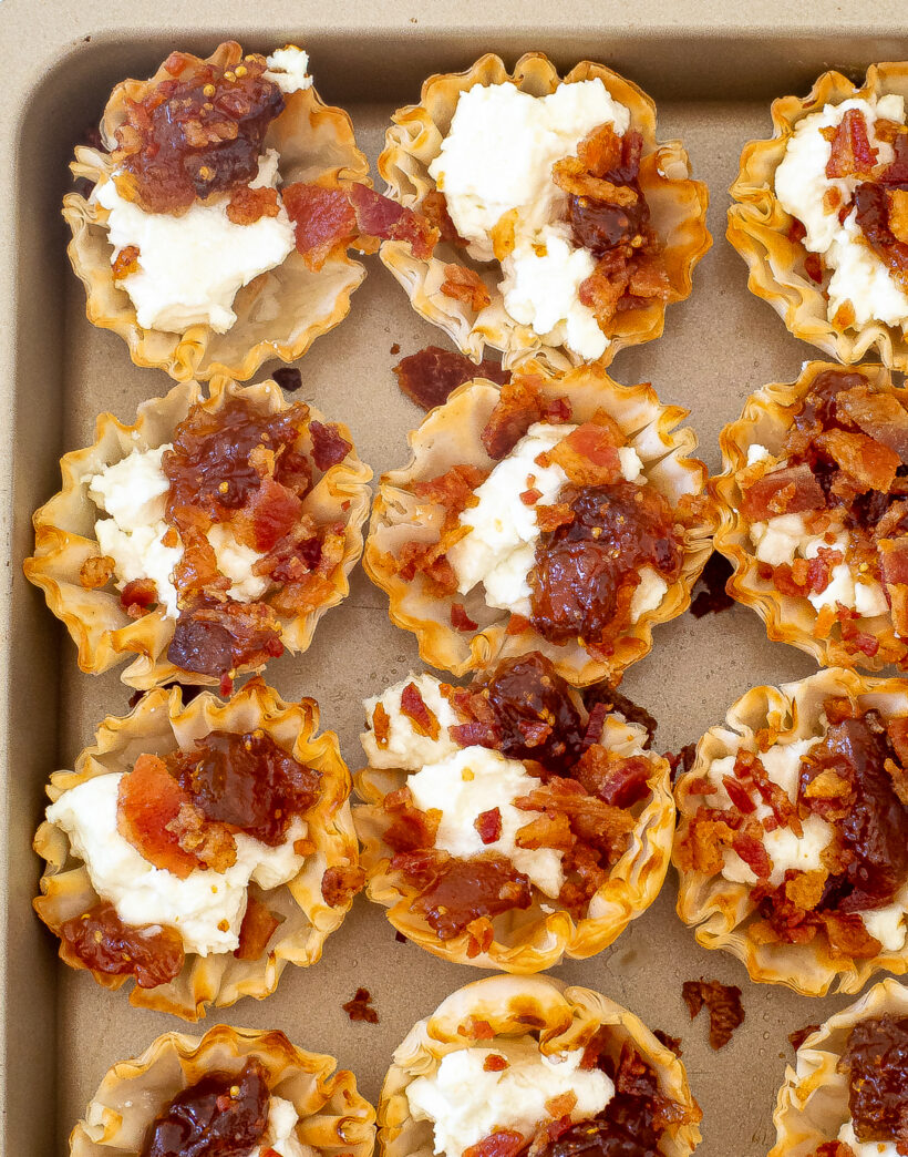 Filled phyllo cups laid on a baking sheet.