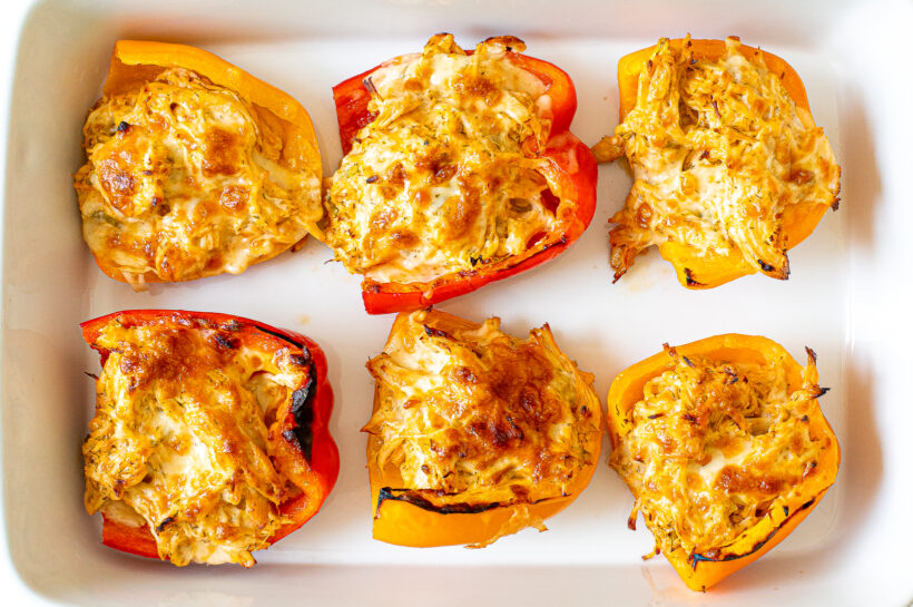 Stuffed peppers after baking in a white dish.