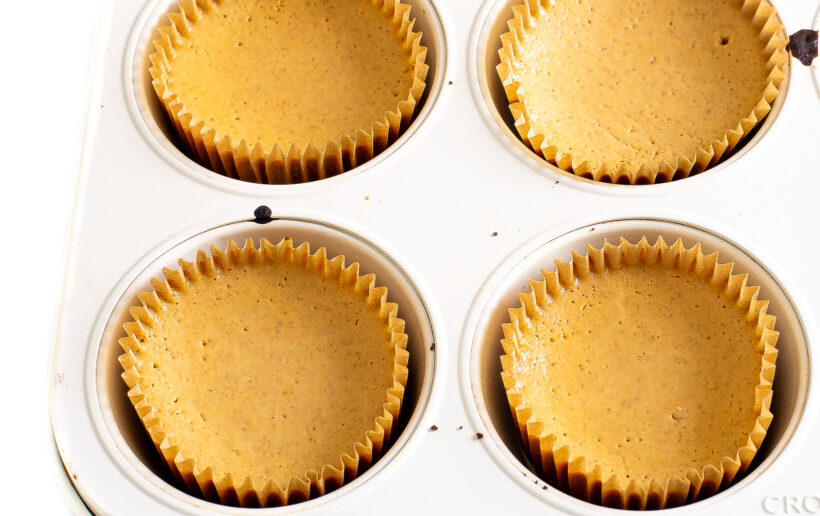 Baked mini pumpkin cheesecakes in muffin tin.