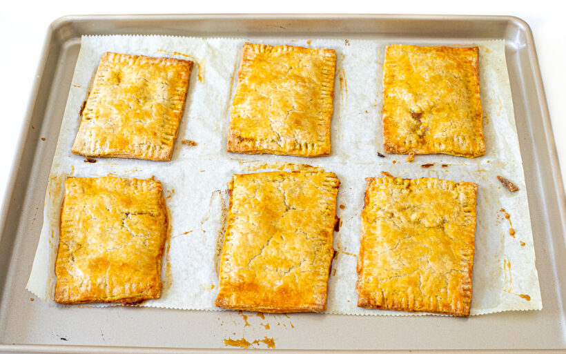 Baked pop tarts on a cookie sheet.