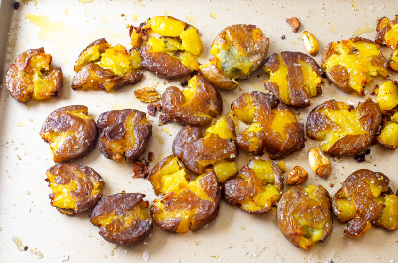 Smashed potatoes on a baking sheet after being baked.