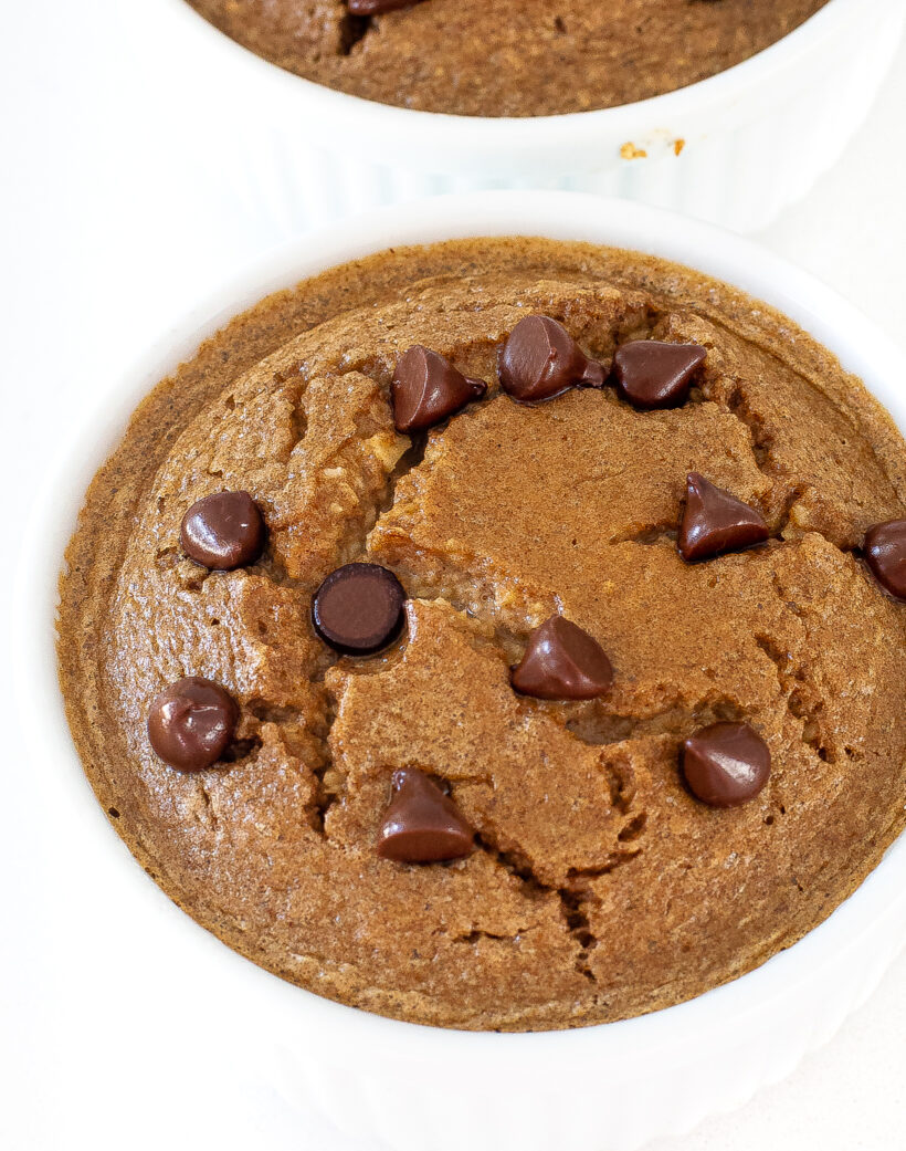 Baked oats in a white ramekin with chocolate chips on top. 