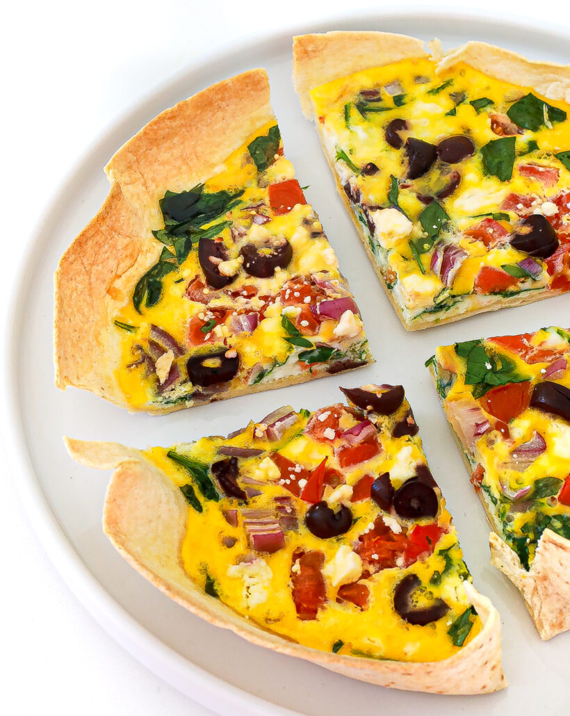 Tortilla with scrambled eggs and toppings on a plate.